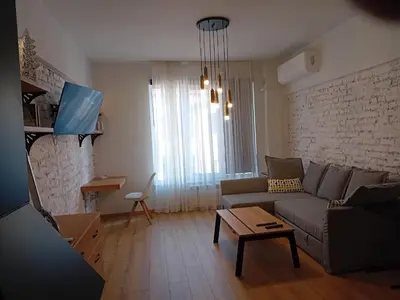 a living room with a couch and a table at Trendy and stylish in city centre for business and leisure in Sofia