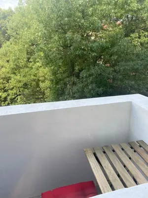 a bench on a balcony with a view of trees at Trendy and stylish in city centre for business and leisure in Sofia