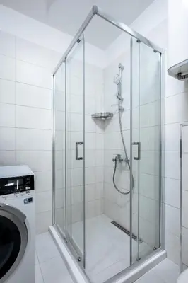a shower with a glass door next to a washing machine at Urban Elegance at Its Finest Stylish 1-BD Flat by Flat Mаnager in Sofia