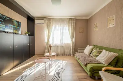 a living room with a green couch and a window at #Maison\u32b6 - A Vibrant, Urban Stay in Sofia