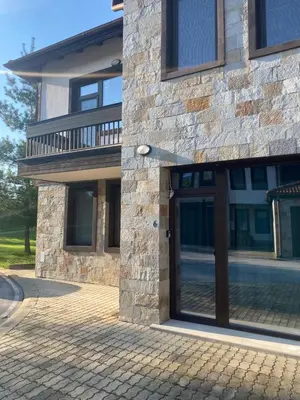 a building with a glass door on the side of it at Vacation house in Pravets golf resort At Pravets Lake in Pravets