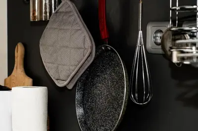 a kitchen counter with a pan and utensils on a wall at Апартамент до парк и метро in Sofia