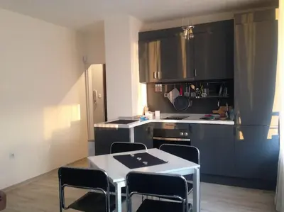 a kitchen with a white table and chairs in it at Апартамент до парк и метро in Sofia