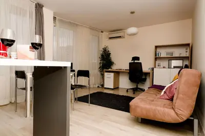 a living room with a couch and a desk at Апартамент до парк и метро in Sofia