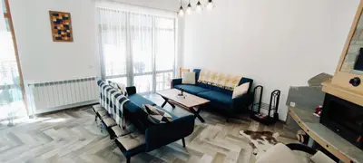 a living room with a blue couch and a table at Mountain Pearls Home 8 in Vodata