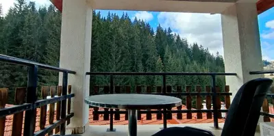 a table on a balcony with a view of trees at Mountain Pearls Home 8 in Vodata