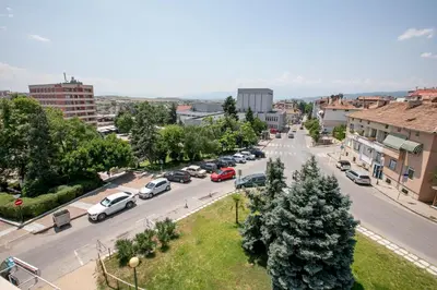 a busy city street with cars parked on the road at Family Hotel Ambrozia in Sandanski