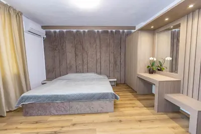 a bedroom with a bed and a wooden floor at Family Hotel Ambrozia in Sandanski