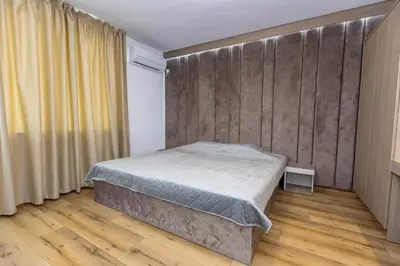 a bedroom with a bed and a wall at Family Hotel Ambrozia in Sandanski