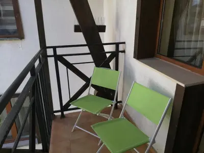 two green chairs sitting next to a balcony at The Castle Mansarde on the slope 7 - Pamporovo in Pamporovo