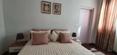 a bedroom with a bed with pink pillows at АПАРТАМЕНТ ЮЛИЯ ДЕЛУКС I in Velingrad