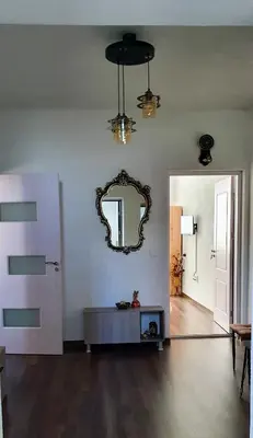 a living room with a mirror and a table at АПАРТАМЕНТ ЮЛИЯ ДЕЛУКС I in Velingrad