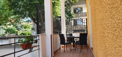 a balcony with a table and chairs on it at АПАРТАМЕНТ ЮЛИЯ ДЕЛУКС I in Velingrad