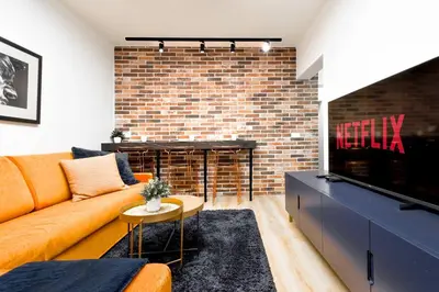 a living room with a couch and a brick fireplace at 2BR by NDK - AC - Desk - Lux Interior - Balcony in Sofia