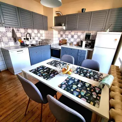a kitchen with a table with chairs and a counter top at Spacious 3 bedroom apartment, close to metro station in Sofia