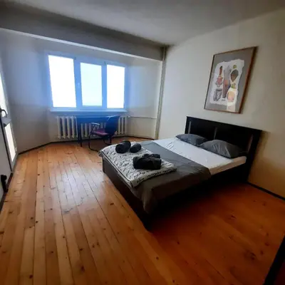 a bedroom with a bed and a wooden floor at Spacious 3 bedroom apartment, close to metro station in Sofia