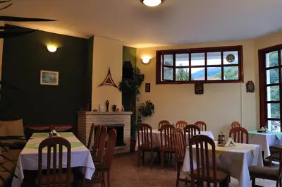 a dining room with tables and chairs and a fireplace at Fisherman's Hut Family Hotel in Beden