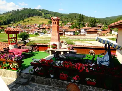 a view of a garden with flowers and a tower at Denis Guest house in Koprivshtitsa