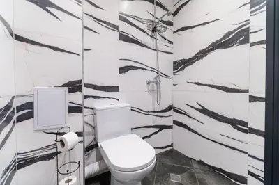 a bathroom with a toilet and black and white wallpaper at City Center Studio Apartments in Plovdiv