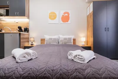 a bedroom with a large bed with towels on it at City Center Studio Apartments in Plovdiv