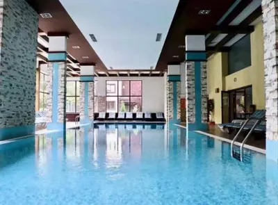 a large swimming pool with blue water in a building at Apartament by Zenit in Terra Complex Massonet D28 near Bansko in Razlog