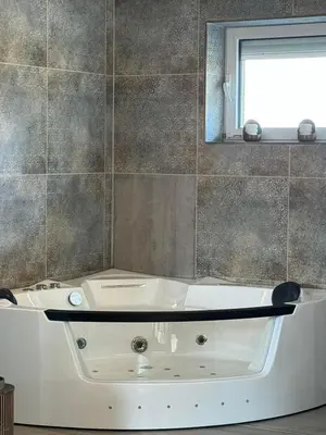a white bath tub in a bathroom with a mirror at Villa Boyana City & Relax with Hot Jacuzzi and Sauna by BookVillaBG in Sofia