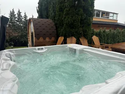 a hot tub in a backyard with chairs at Villa Boyana City & Relax with Hot Jacuzzi and Sauna by BookVillaBG in Sofia