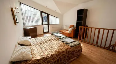a bedroom with a bed and a chair and windows at South Facing Bright Mountain View Penthouse - 2 balconies, 300mbps WIFI, washer in Bansko