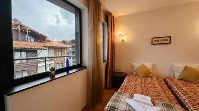 a room with two beds and a large window at South Facing Bright Mountain View Penthouse - 2 balconies, 300mbps WIFI, washer in Bansko