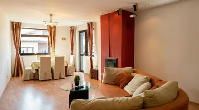 a living room with a couch and a table at South Facing Bright Mountain View Penthouse - 2 balconies, 300mbps WIFI, washer in Bansko