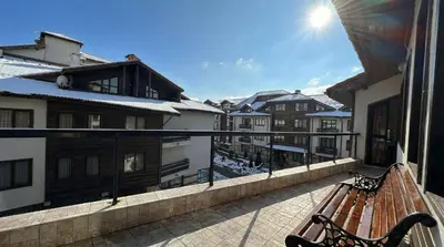 a bench on a balcony with snow covered buildings at South Facing Bright Mountain View Penthouse - 2 balconies, 300mbps WIFI, washer in Bansko