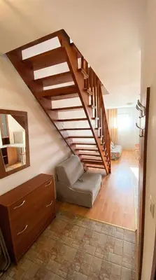 a room with a staircase with a couch and a mirror at 1BR Bright 300mbps WIFI Duplex - Two Floors in Bansko