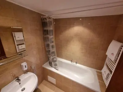 a bathroom with a tub and a toilet and a sink at 1BR Homey Duplex 300mbps WIFI - Two Floor with washer in Bansko