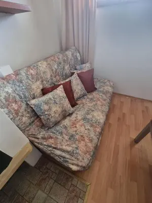 a couch sitting in the corner of a living room at 1BR Homey Duplex 300mbps WIFI - Two Floor with washer in Bansko