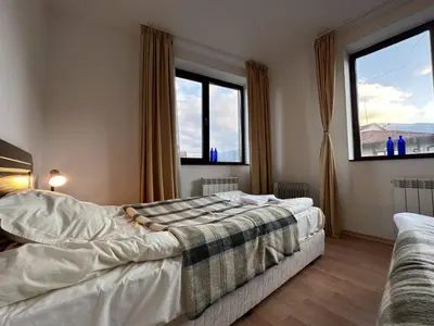 a bedroom with two beds and two windows at 2BR Mountain View Apartment - Washer, 300mbps WIFI, Aircon in Bansko