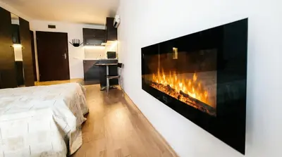 a bedroom with a fireplace in the wall at Mountain Paradise 2 - Quiet Cosy Studio - Balcony, Wifi in Bansko