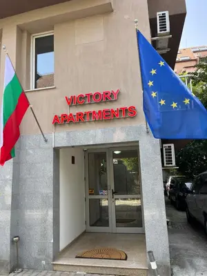 a flag and an european flag in front of a building at APARTHOTEL VICTORY SOFIA in Sofia