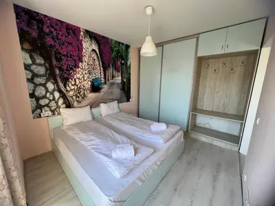 a bed in a room with a painting on the wall at APARTHOTEL VICTORY SOFIA in Sofia