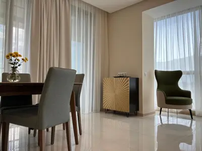 a dining room with a table and chairs and a television at Point Sofia Grand Suite in Sofia