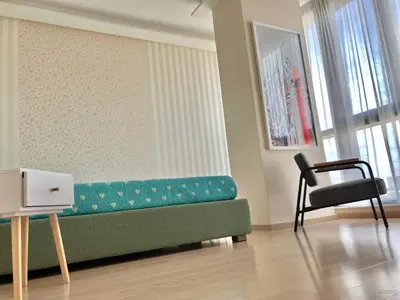 a living room with a green couch and a chair at Point Sofia Grand Suite in Sofia