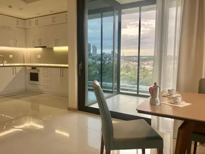 a kitchen with a table and chairs and a large window at Point Sofia Grand Suite in Sofia