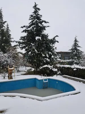 a swimming pool in a yard covered in snow at Славина къща in Perushtitsa