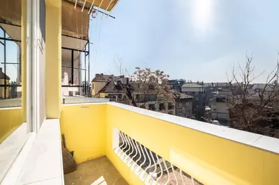 a yellow balcony with a view of a city at Central located 1BDR peaceful apt Fast Wi-fi in Sofia