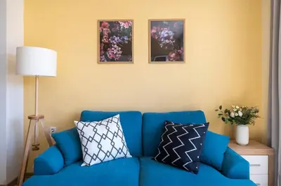 a blue couch with pillows in a living room at Central located 1BDR peaceful apt Fast Wi-fi in Sofia