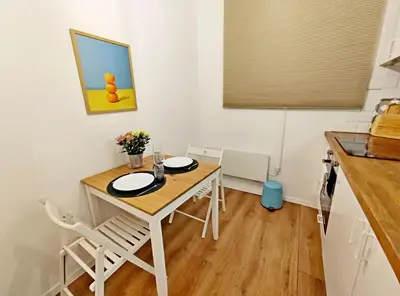 a small kitchen with a wooden table and chairs at Top Centre 1 Bedroom Apt next to Vitosha Blvd. in Sofia