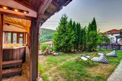 a house with a yard with chairs and a tub at The Pine Living - Ski & SPA in Lyevochevo