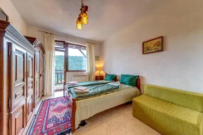 a bedroom with a bed and a couch and a window at The Pine Living - Ski & SPA in Lyevochevo