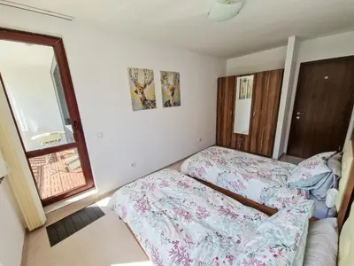 a bedroom with two beds and a window at Sunny Apartment C25 in Borovets