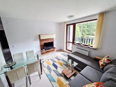 a living room with a couch and a table at Sunny Apartment C25 in Borovets