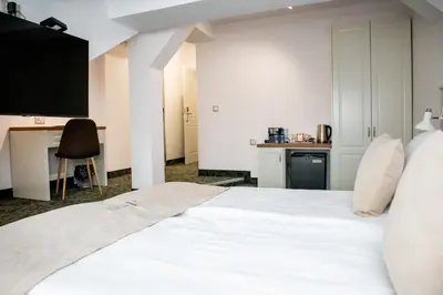 a bedroom with a large white bed and a desk at Agora Boutique Hotel in Sofia